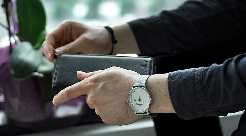 黒い服の男性と黒の長財布